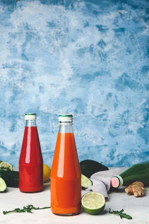 Bottles of fresh vegetable juices on white table