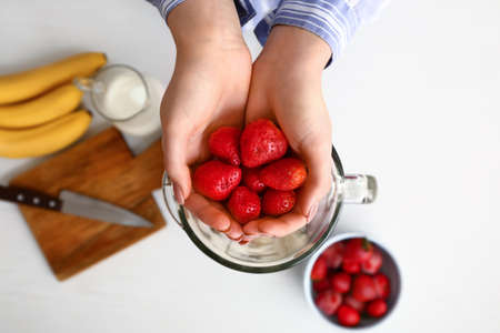 Woman preparing tasty milkshake on table, top viewの写真素材