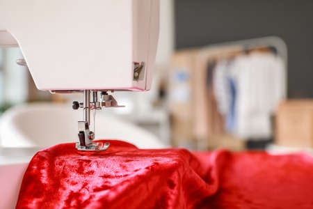 Sewing machine with fabric in atelier, closeup