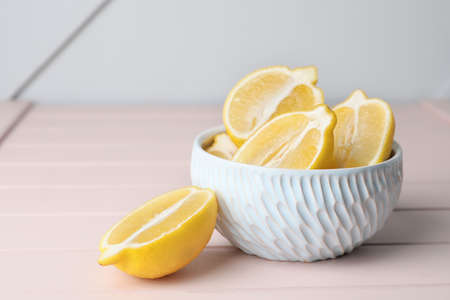 Fresh ripe lemons in bowl on tableの写真素材