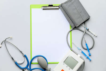 Composition with sphygmomanometer and clipboard on light backgroundの写真素材