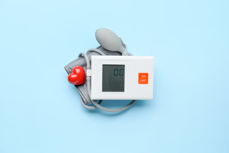 Electronic sphygmomanometer on color background
