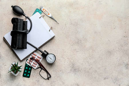 Composition with sphygmomanometer, notebook and pills on gray backgroundの写真素材