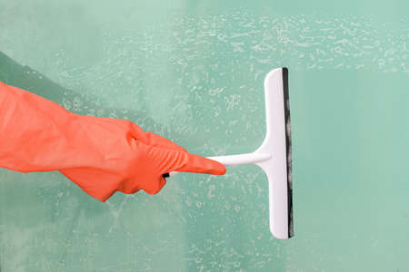 Woman cleaning window at homeの写真素材