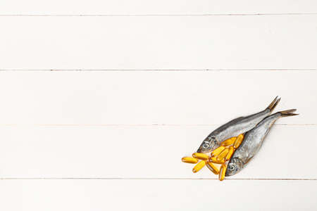 Fish with oil pills on white tableの写真素材