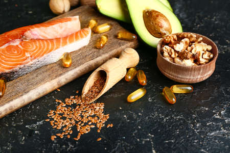 Set of healthy products with high omega 3 and fish oil pills on dark backgroundの写真素材
