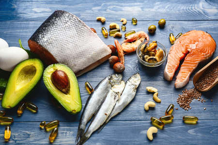 Set of healthy products with high omega 3 and fish oil pills on wooden tableの写真素材