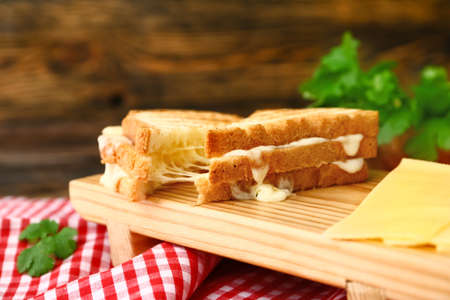 Tasty sandwiches with cheese on table