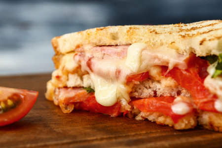 Tasty sandwich with cheese, meat and tomatoes on table, closeupの写真素材