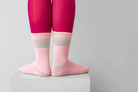 Legs of young woman in socks and tights on light backgroundの写真素材