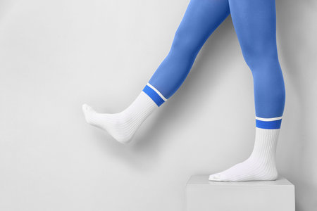 Legs of young woman in socks and tights on light backgroundの写真素材