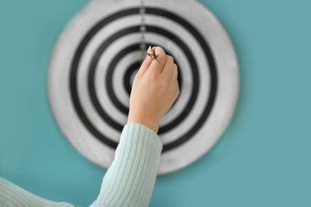 Young woman playing darts indoorsの写真素材