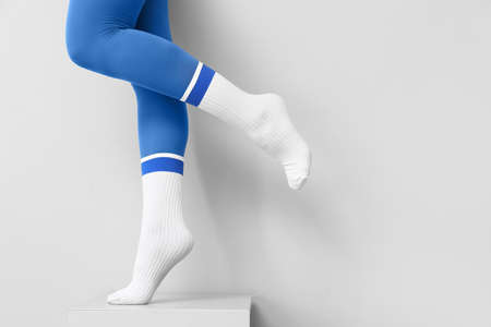 Legs of young woman in socks and tights on light backgroundの写真素材