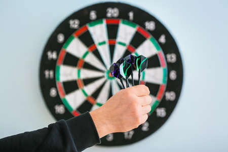 Young man playing darts indoors