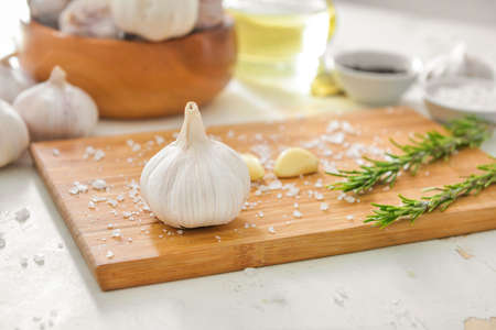 Fresh garlic with salt and herbs on white tableの写真素材