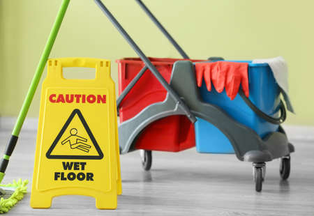 Caution sign with janitor's trolley indoors