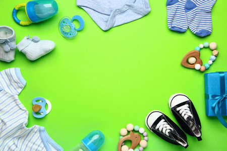 Frame made of baby clothes and accessories on color backgroundの写真素材
