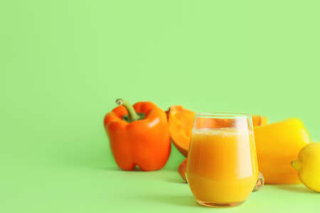 Glass of fresh vegetable juice on color backgroundの写真素材