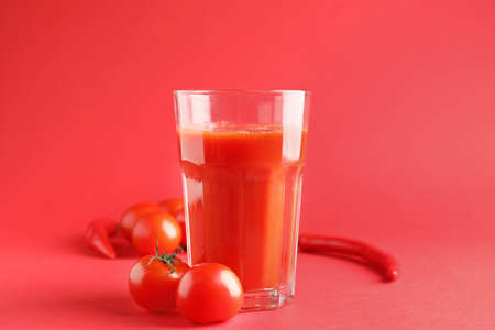 Glass of fresh vegetable juice on color backgroundの写真素材