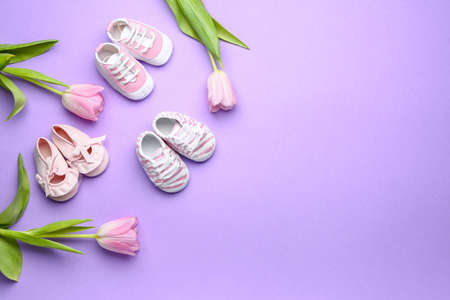 Different baby booties with flowers on color backgroundの写真素材