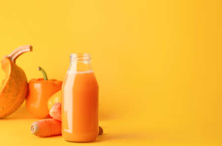 Bottle of fresh vegetable juice on color backgroundの写真素材