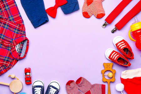Frame made of baby clothes and accessories on color backgroundの写真素材