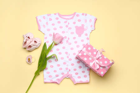 Baby clothes with accessories and gift on color backgroundの写真素材