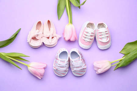 Different baby booties with flowers on color backgroundの写真素材