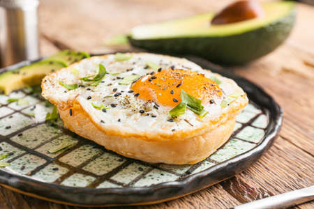 Sandwich with fried egg on plate, closeup