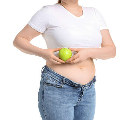 Overweight woman with apple on white background. Weight loss conceptの写真素材