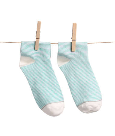 Cotton socks hanging on rope against white backgroundの写真素材