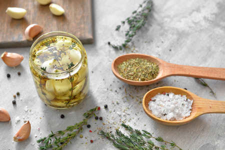 Jar with garlic, oil and spices on gray backgroundの写真素材