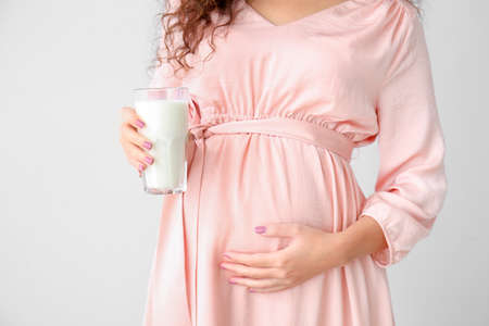 Pregnant African-American woman with milk on gray backgroundの写真素材