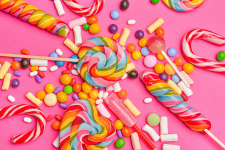 Assortment of tasty candies on color background