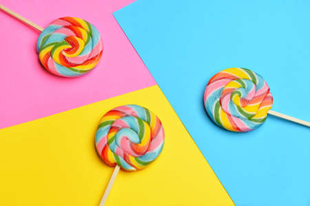 Tasty lollipops on color background