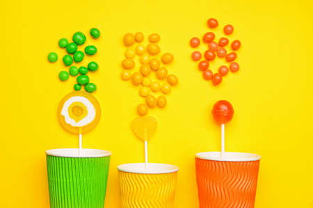 Cups with tasty candies on color backgroundの写真素材