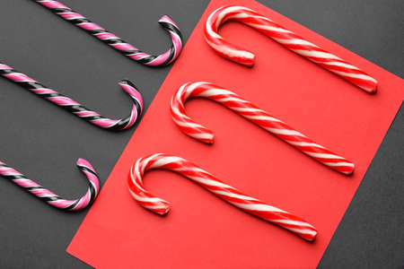 Tasty candy canes on color background