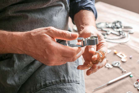 Jeweler examining adornment in workshop, closeupの写真素材