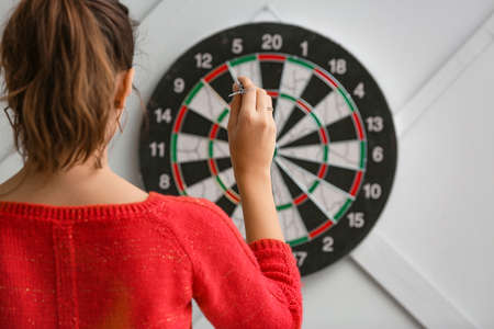 Young woman playing darts indoorsの写真素材