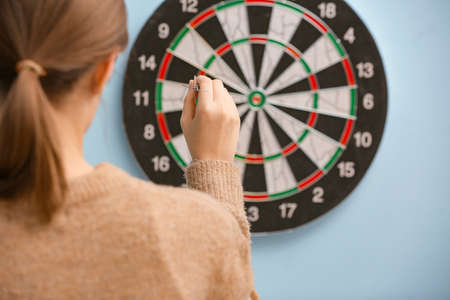 Young woman playing darts indoorsの写真素材