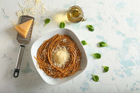 Plate with tasty pasta and cheese on color backgroundの写真素材