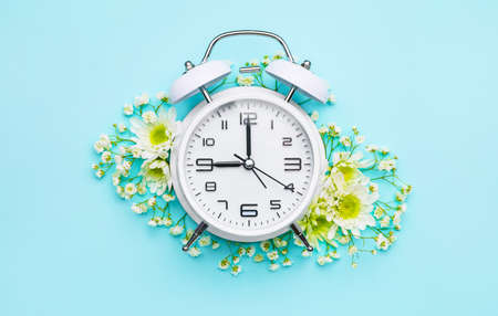 Alarm clock with flowers on color backgroundの写真素材