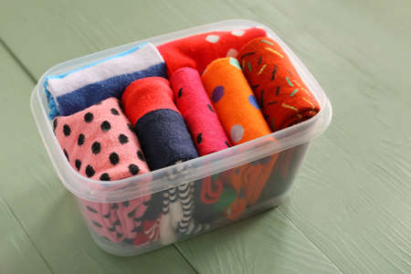 Box with different socks on wooden backgroundの写真素材