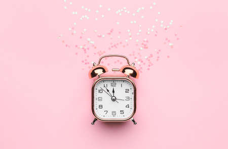Alarm clock with confetti on color backgroundの写真素材