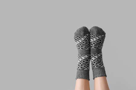 Legs of woman in socks on gray background