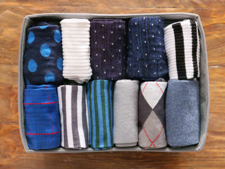 Box with different socks on wooden backgroundの写真素材