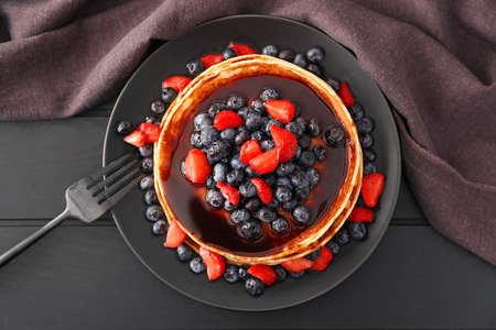 Plate with stack of tasty pancakes on tableの写真素材