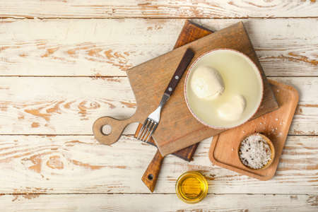 Mozzarella cheese with oil on white wooden backgroundの写真素材