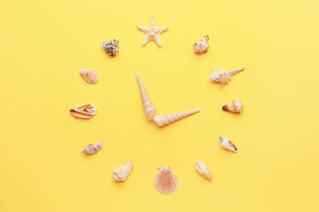 Creative clock made of seashells on color backgroundの写真素材
