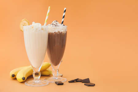 Glasses of tasty milkshakes on color backgroundの写真素材